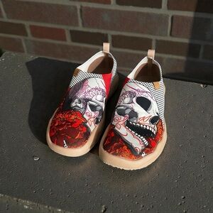 UINStylish slip-on loafers with a distinctive skull and red rose graphic print.